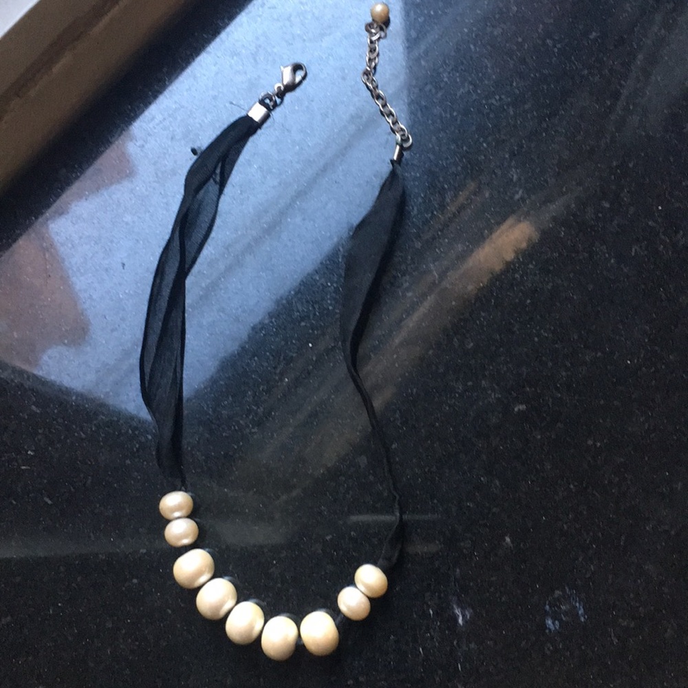 Necklace with faux pearls on black ribbon.